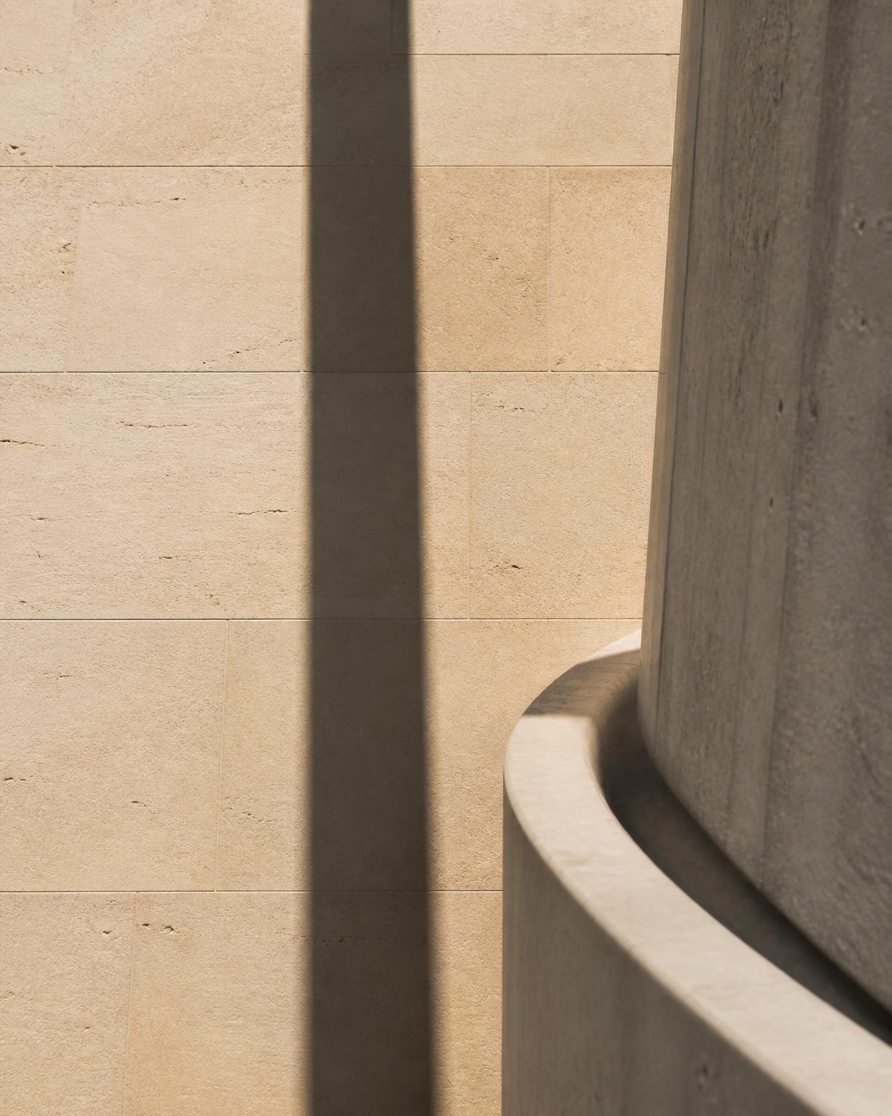 Daylight across a limestone and concrete façade — an abstract study of permanence